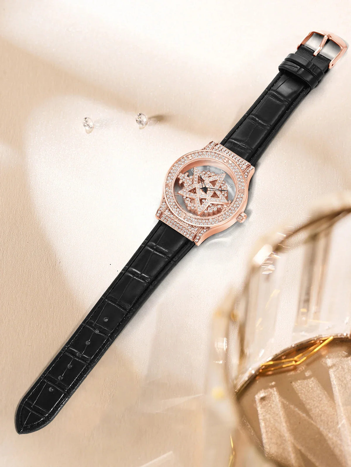 Luxury watch with black strap and rose gold case on a reflective surface